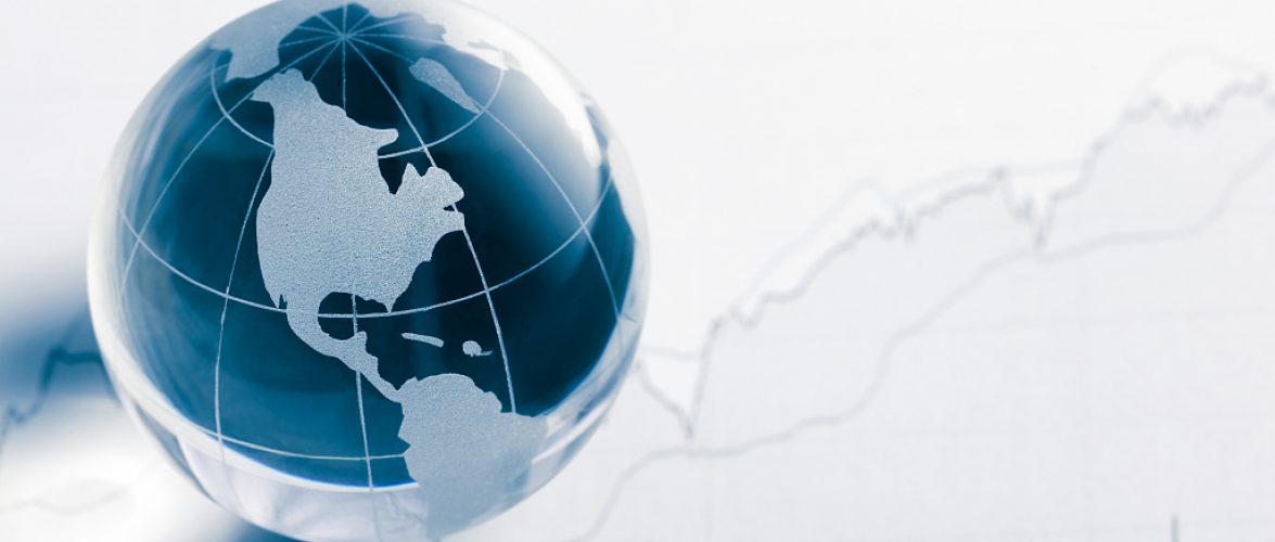 Business concept. Glass globe (america map) and stock market chart on newspaper background