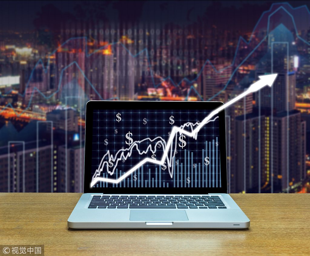 Stock exchange market trading graph over the screen of computer laptop on wood table over the photo blurred of trading graph background, business marketing trade concept