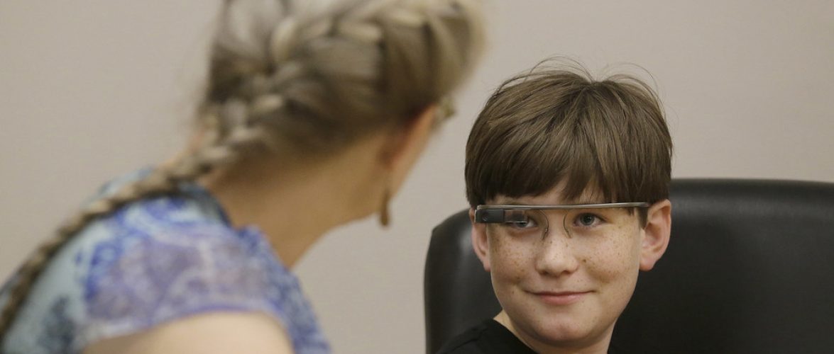 Julian Brown, right, talks with his mother Kristen during a meeting with Jena Daniels, a clinical research coordinator at The Wall Lab in Stanford, Calif., Wednesday, June 22, 2016. Like many autistic children, Brown, 10, has trouble reading emotions in people's faces, one of the biggest challenges for people with the neurological disorder. Now Brown is getting help from "autism glass" - an experimental device that records and analyzes faces in real time and alerts him to the emotions they're expressing. (AP Photo/Jeff Chiu)