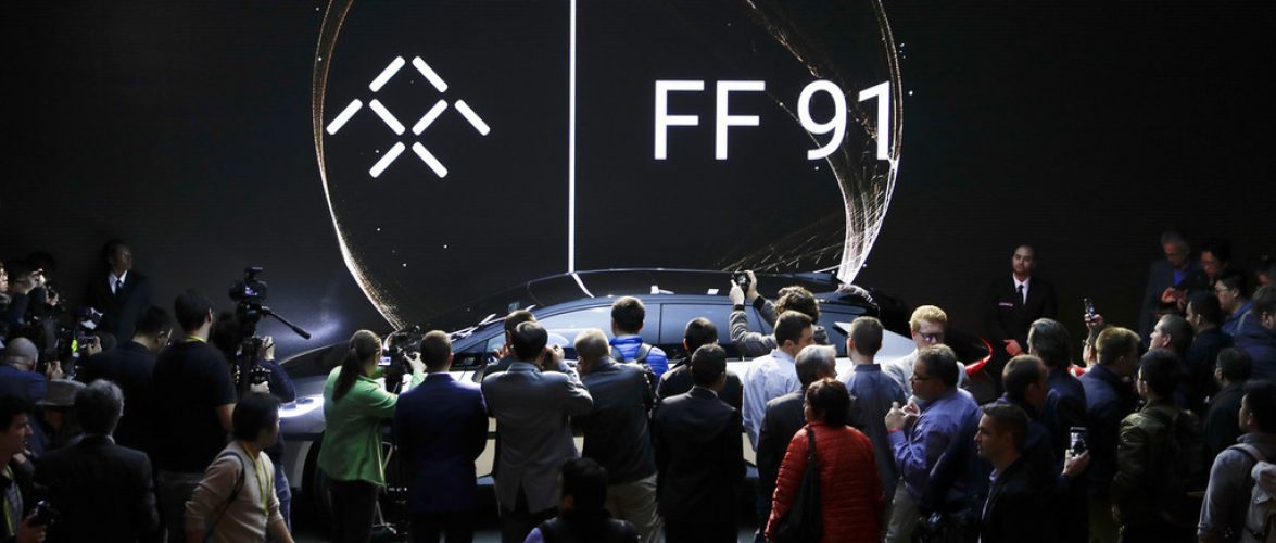 People gather around the Faraday Future's FF 91 electric car during a news conference at CES International on Tuesday, Jan. 3, 2017, in Las Vegas. (AP Photo/Jae C. Hong)