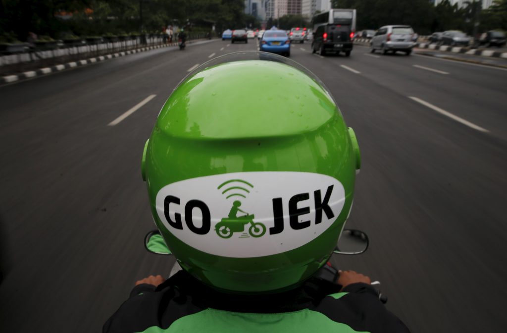 A Gojek driver rides his motorcycle through a business district street in Jakarta, June 9, 2015. Jakarta's traffic jams are a constant vexation for the city's 10 million residents. The Indonesian capital's glaring inefficiencies have also created opportunities for the likes of Makarim, who has launched a smartphone app, GO-JEK, that lets users summon a motorbike rider to weave them quickly through gridlocked traffic, deliver a meal or even get the shopping. Picture taken June 9, 2015. REUTERS/Beawiharta