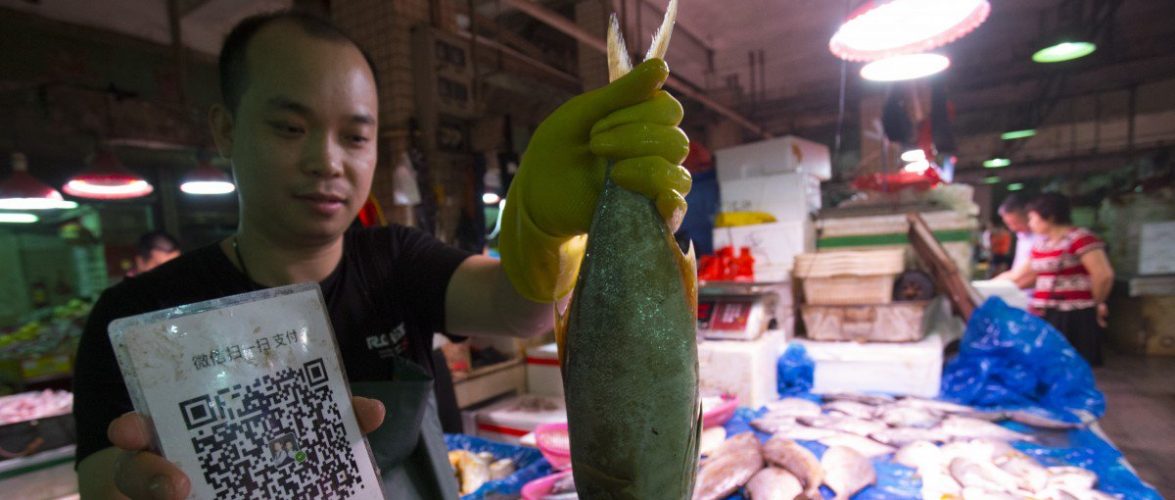 Fish Vendor Wu Weibin at a wet market in Shenzhen, China, takes mobile payment. Photo: SCMP
