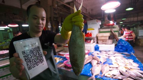 Fish Vendor Wu Weibin at a wet market in Shenzhen, China, takes mobile payment. Photo: SCMP
