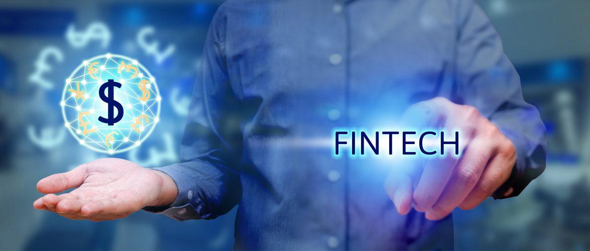 Financial technology concept, man pressing text fintech and holding global currency. Source: Tuchong.