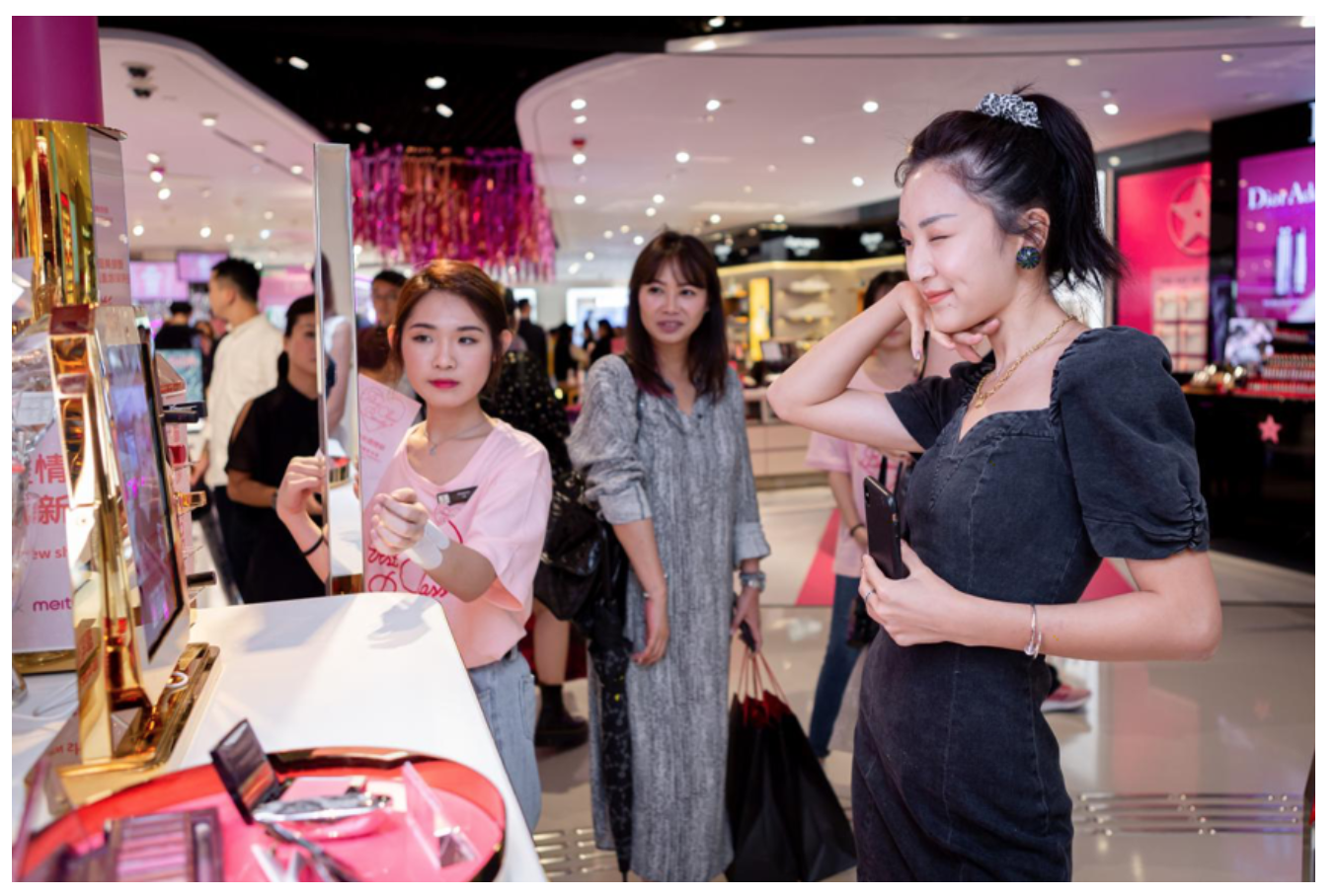 A woman tries Meitu's Meitu’s smart mirror MeituGenius in a DFS store. 