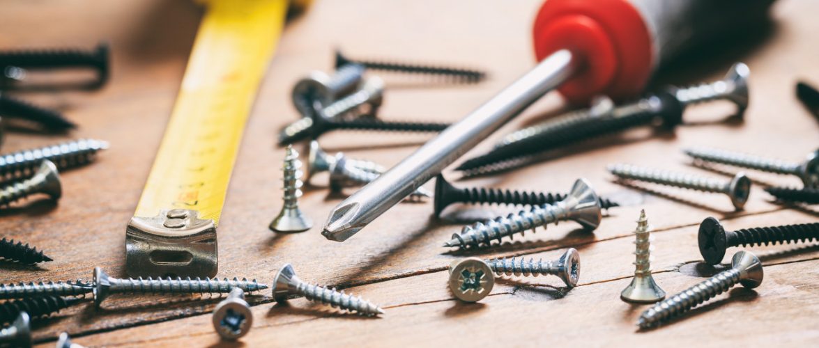 Screwdriver, nails and meter on wooden background. Photo : Tuchong
