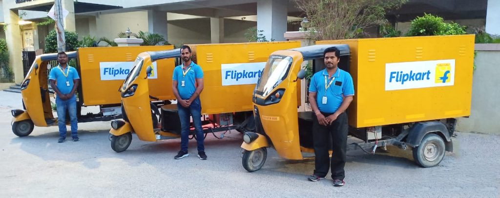 Photo of Flipkart's delivery riders alongside electric three-wheelers used to fulfill e-commerce orders.