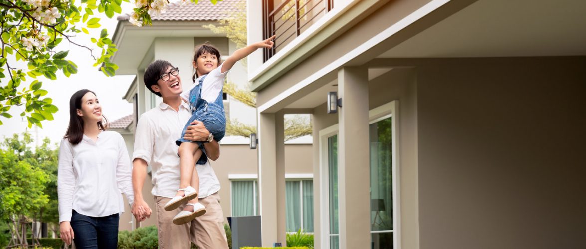 Beautiful family portrait smiling outside their new house with sunset. Photo: Tuchong