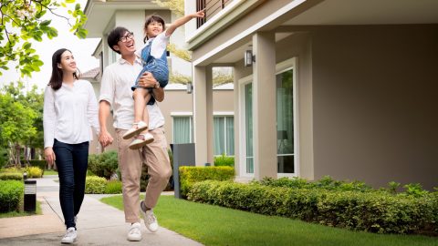 Beautiful family portrait smiling outside their new house with sunset. Photo: Tuchong
