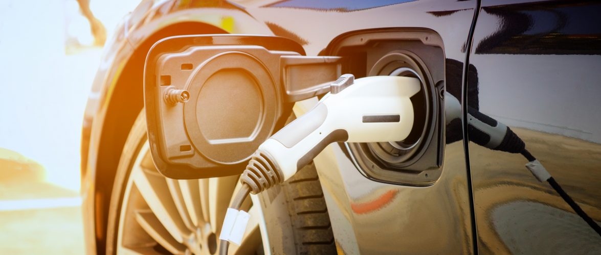 Charging modern electric car battery on the street which are the future of the Automobile, Close up of power supply plugged into an electric car being charged for hybrid . New era of vehicle fuel.