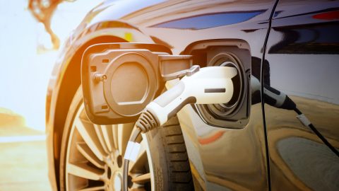 Charging modern electric car battery on the street which are the future of the Automobile, Close up of power supply plugged into an electric car being charged for hybrid . New era of vehicle fuel.