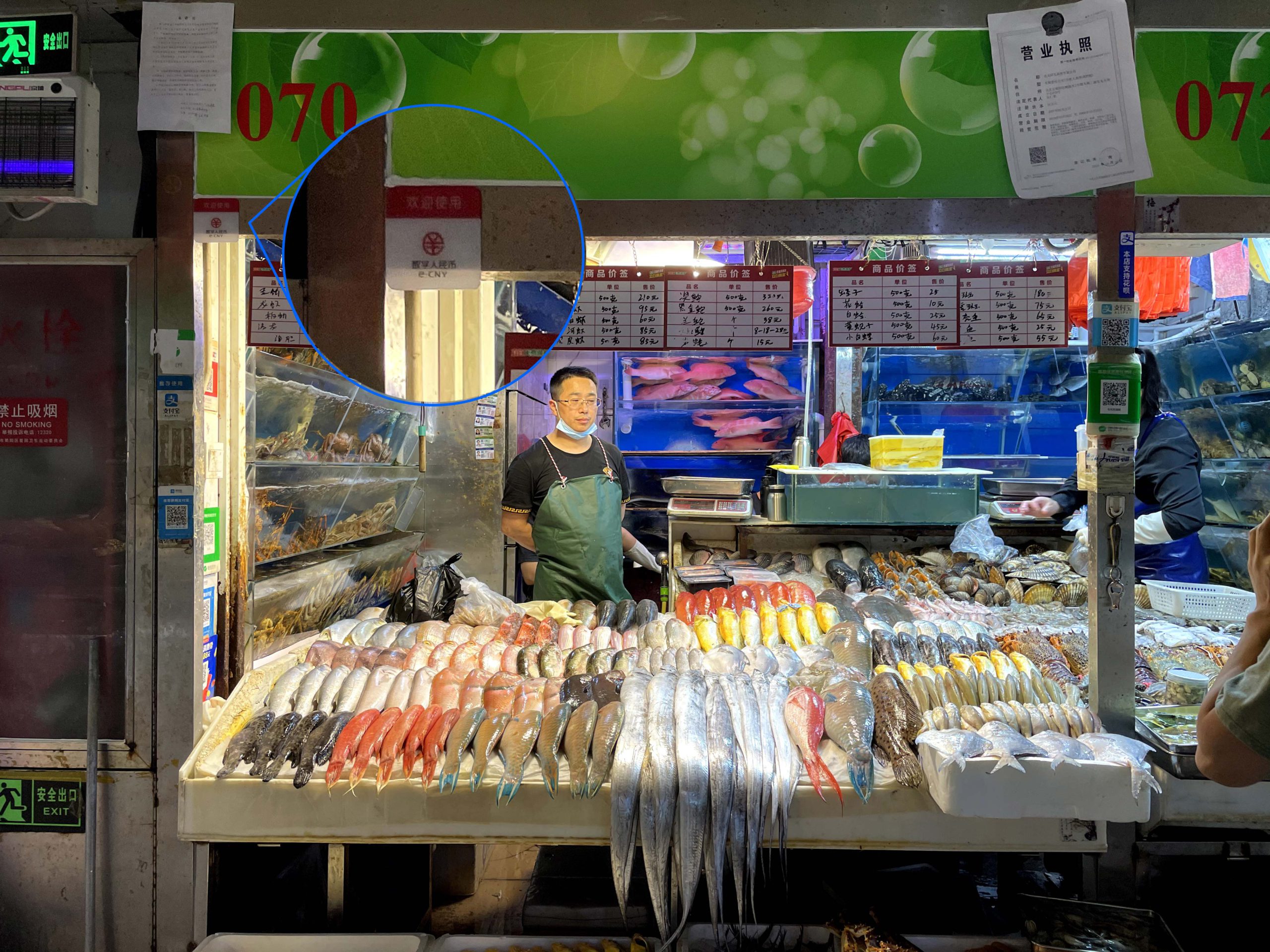 One of the seafood stands in Sanyuanli market where the “Digital Yuan” sign is posted under the stand’s number. Photo by KrASIA.