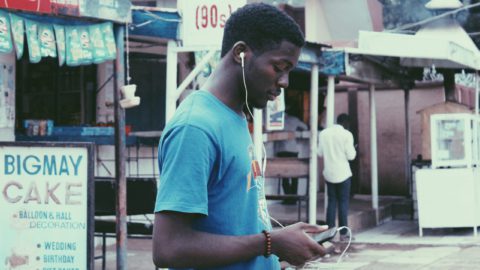 A teenager using his phone in Nigeria. Photo by Muhammadtaha Ibrahim Ma'aji on Unsplash.