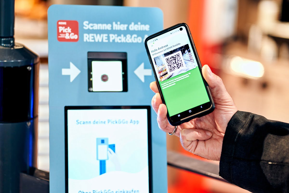 A customer scans his QR code on an app to enter the REWE store. Photo courtesy of Rewe via NoCamels.