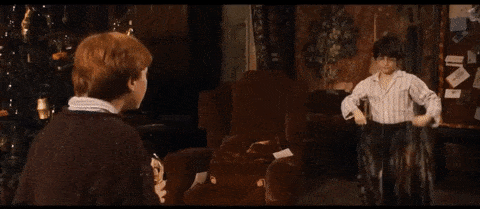 GIF of Harry Potter receiving an anonymously gifted invisibility cloak from Albus Dumbledore, his headmaster, in the Harry Potter and the Sorcerer’s Stone movie.