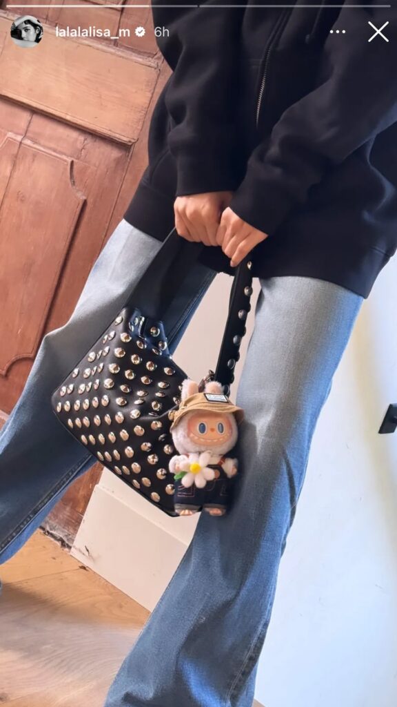 Screenshot of an Instagram story posted by Blackpink's Lisa, featuring her holding a handbag with a Labubu doll attached.