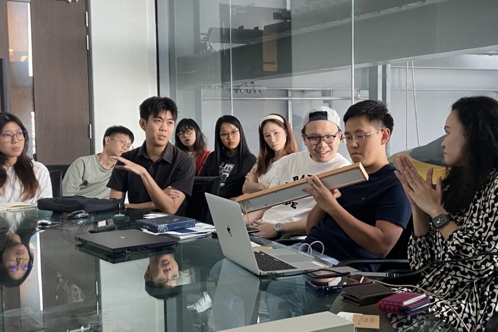 Photo of representatives from local design firms Archideas Design and Craftsmen Studio exploring the Mui Board, a tech-enabled display crafted from natural wood by Mui Lab.