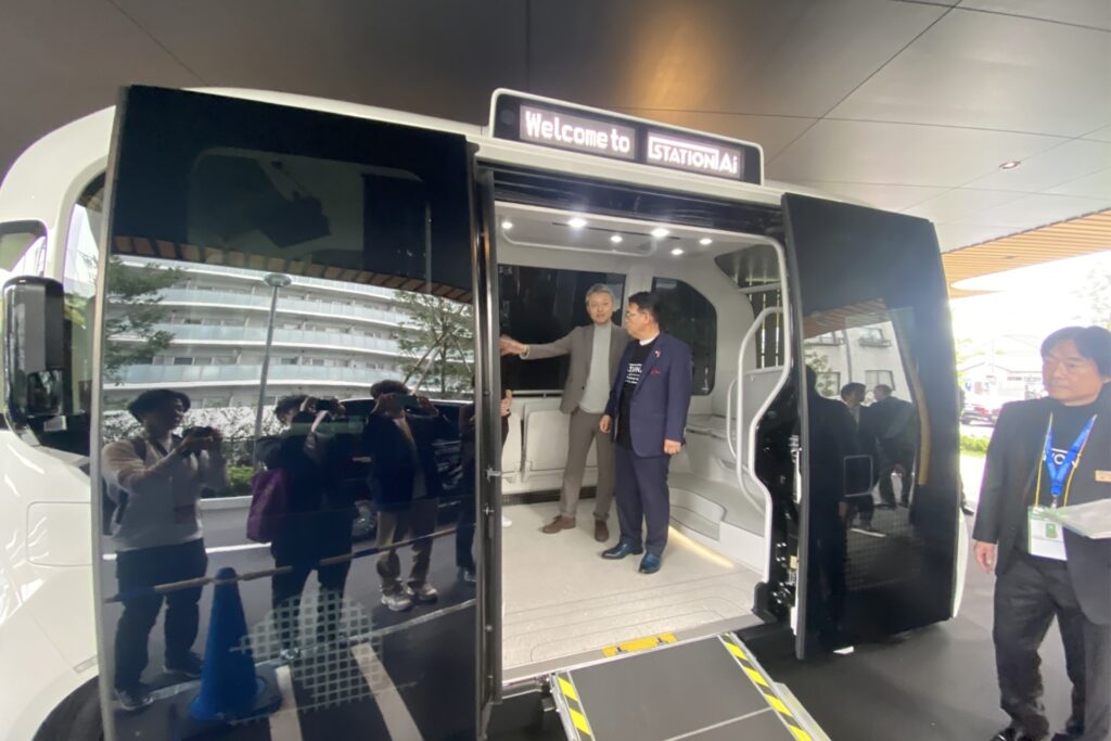 Photo of Aichi governor Hideaki Omura examining a unit of Toyota’s e-Palette self-driving vehicle at Station Ai.