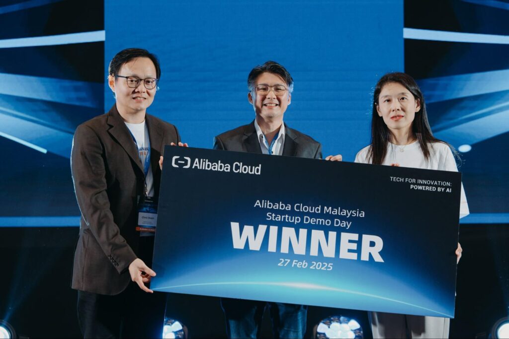 Photo of Kayel Lee (center), founder of Paix Tech, being awarded the demo day’s top prize during the February 27 event.