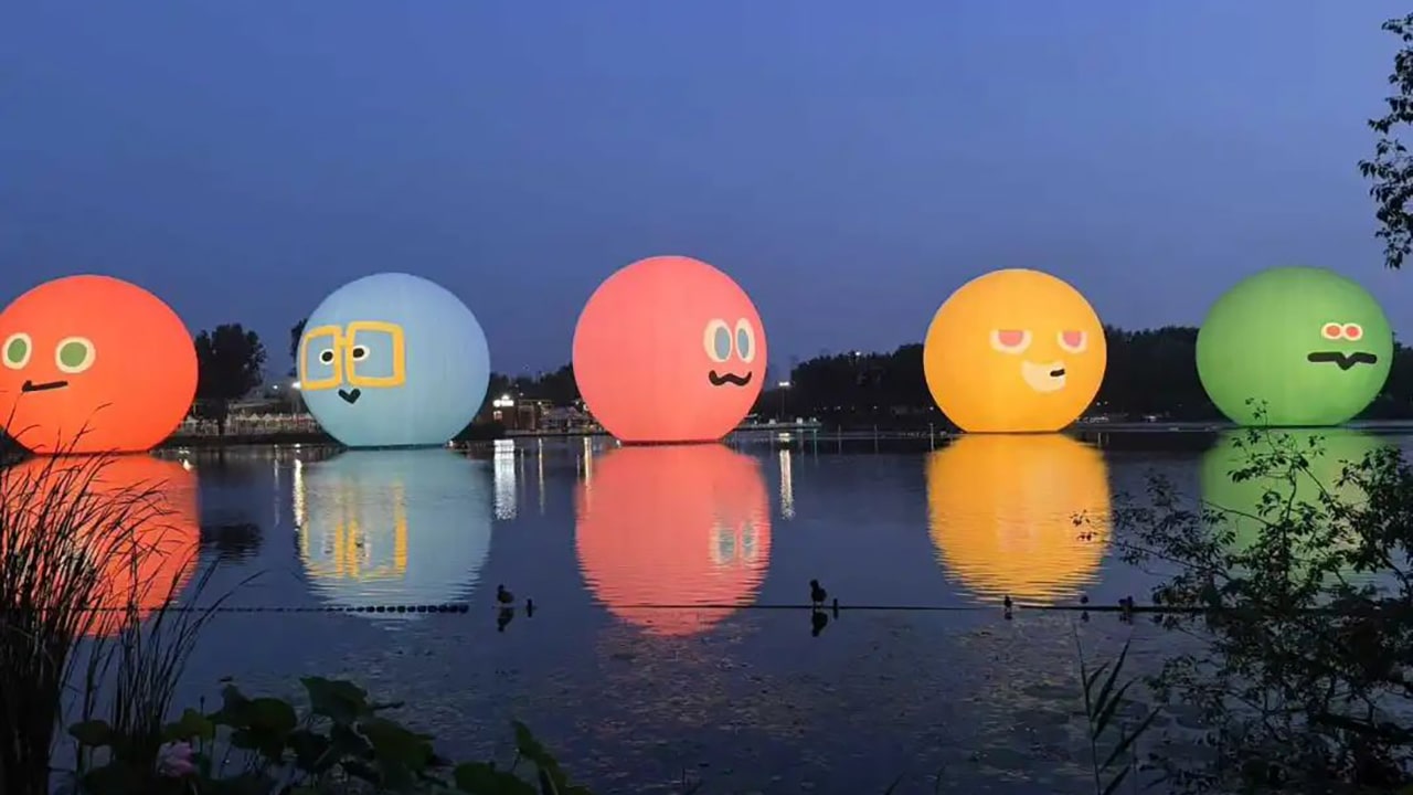 Photo of five spherical structures floating along Chaoyang Park, symbolizing members of the band Mayday.