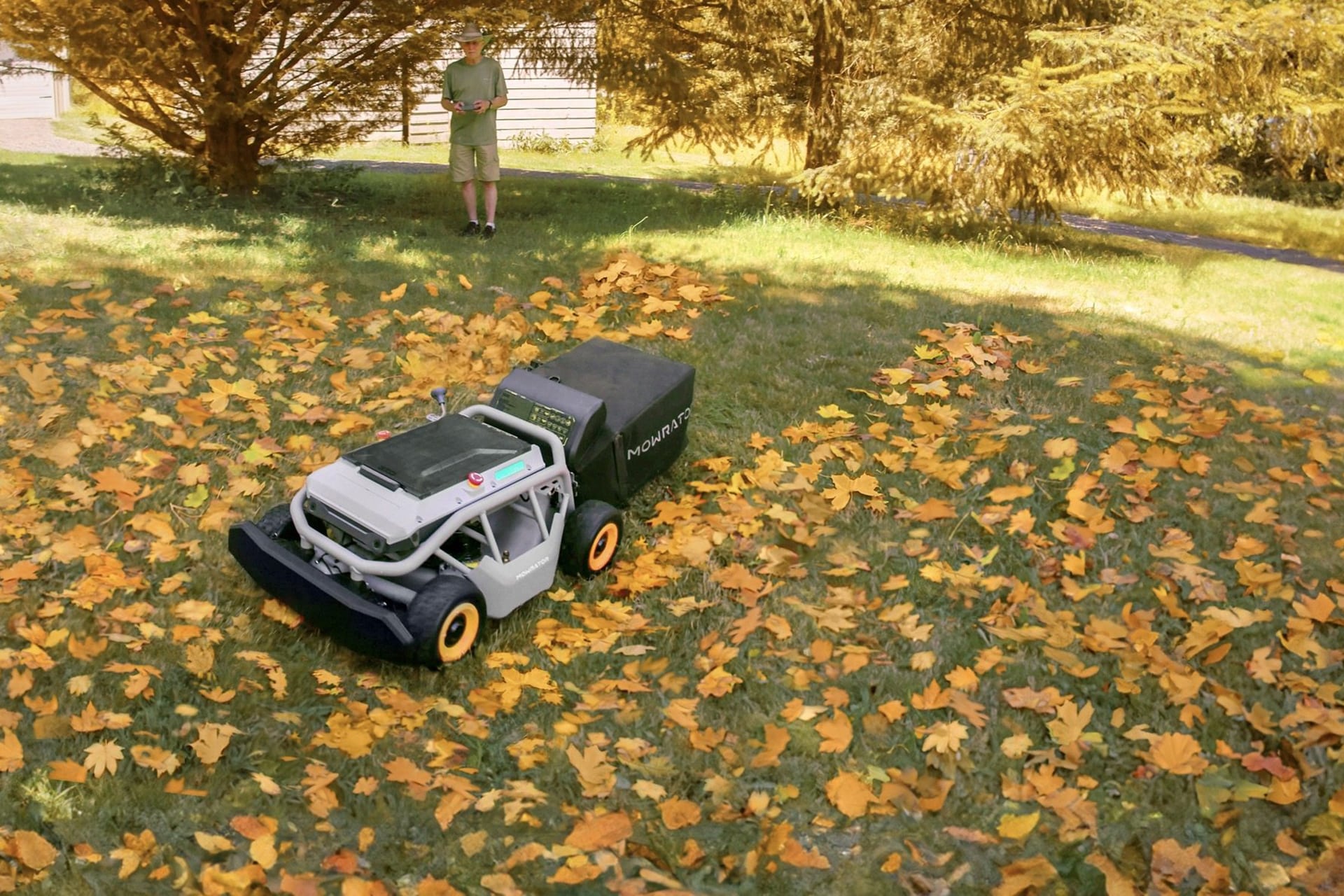 Photo shows a Mowrator S1 robot sweeping leaves off a lawn, remotely controlled by a user.