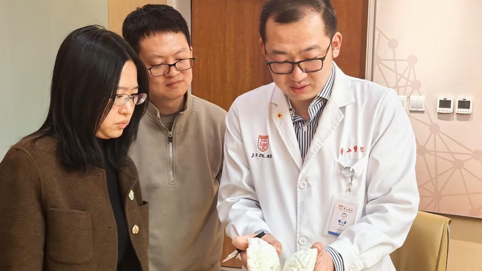 Li Xue (left) and Zhao Zhengtou (center), co-founders of StairMed, conduct preoperative planning with Lu Junfeng at Huashan Hospital, Fudan University. The team was preparing for a clinical trial procedure involving brain-computer interfacing. Photo source: Chen Yaoxu (Xinhua).