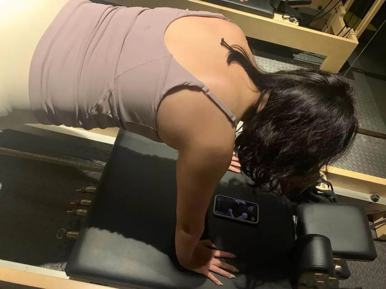 Photo of Minnie exercising with support from Rafayel, present on her phone.