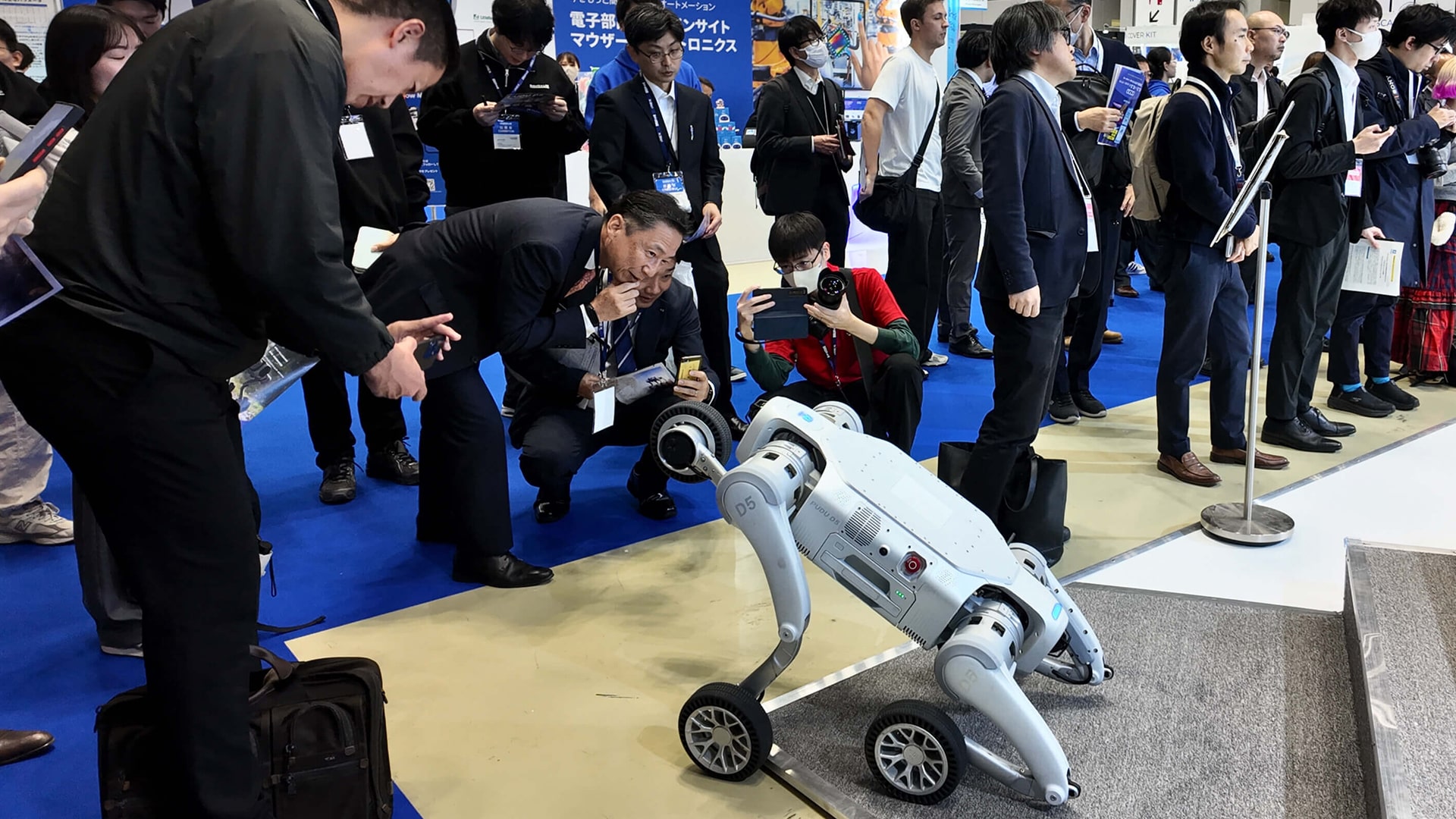 Photo of visitors at the iREX 2025 event in Tokyo, Japan, interacting with the new D5 industrial robot.