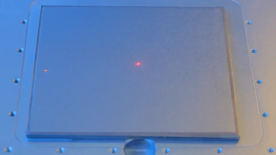 The E3 laser engraver, producing colors on a metal surface with microscopic precision.