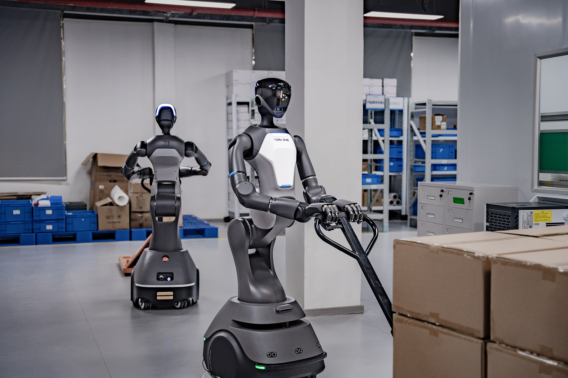 Photo of PaXini’s TORA-ONE robots operating pallet jacks.