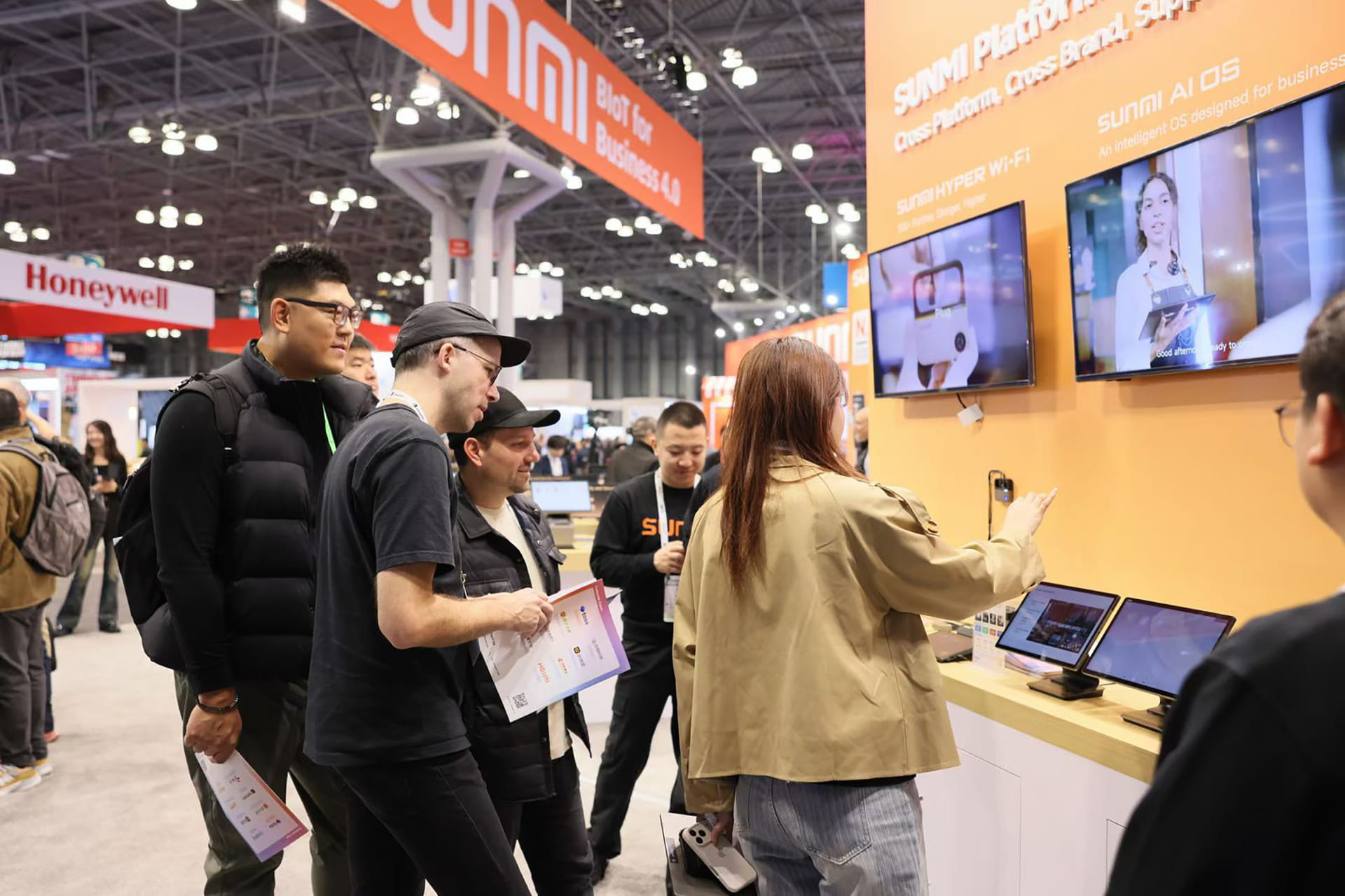 Photo shows NRF 2026 attendees getting hands-on with Sunmi devices.
