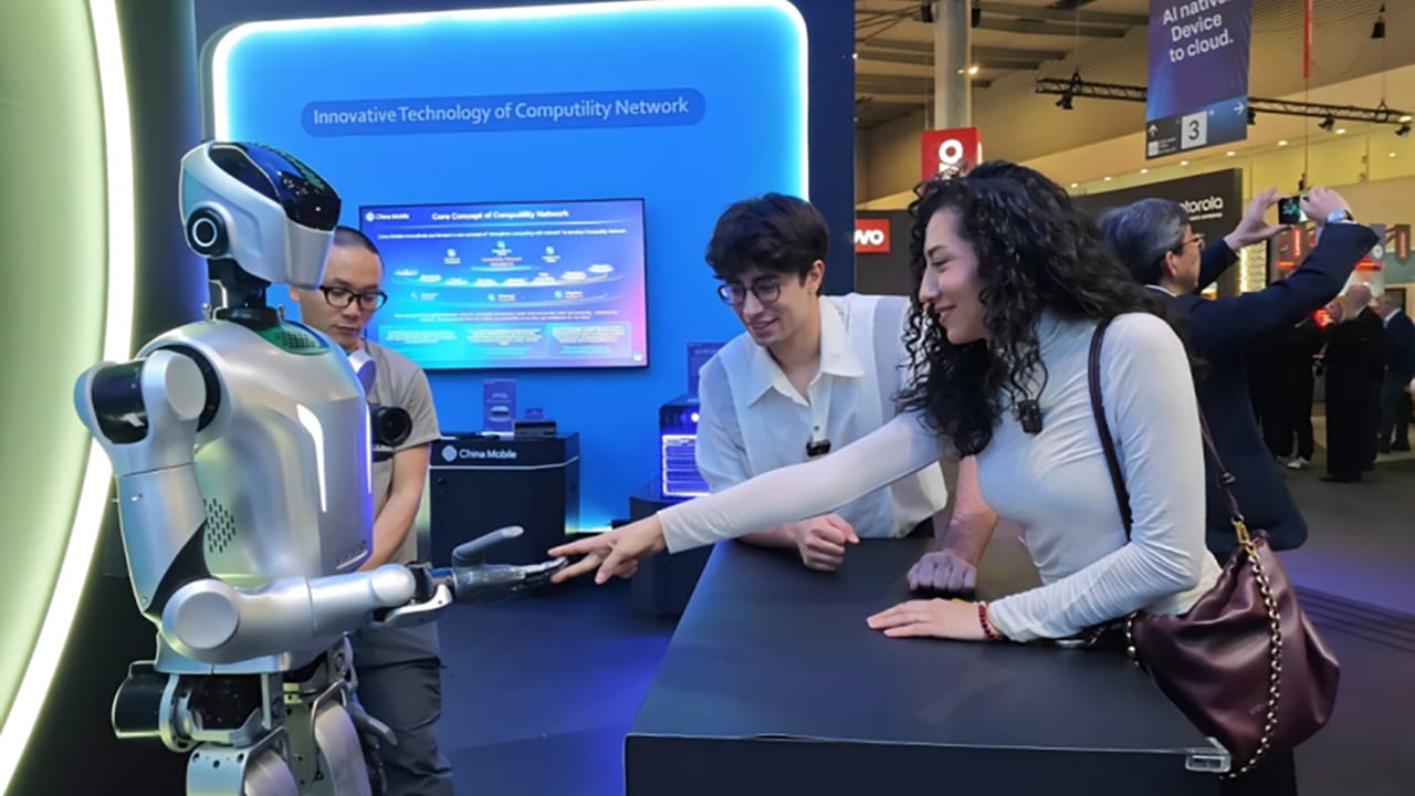 Photo shows visitors playing rock-paper-scissors with the Kuavo humanoid robot, developed by Leju Robotics and integrated with China Mobile’s 5G-A technology.