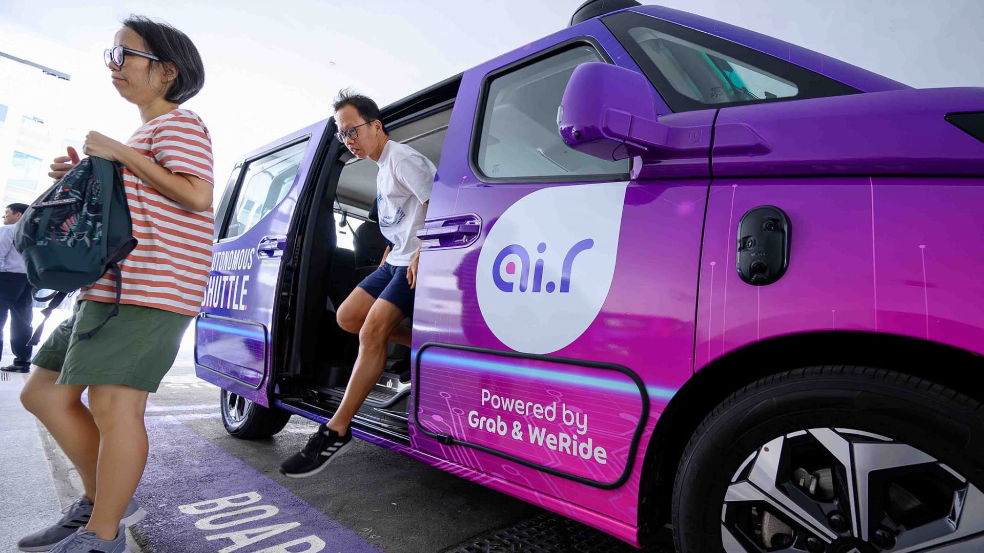 Photo shows passengers alighting from a robotaxi deployed in Singapore under the Ai.R (autonomously intelligent ride) service, piloted by Grab and WeRide in Singapore’s Punggol district.