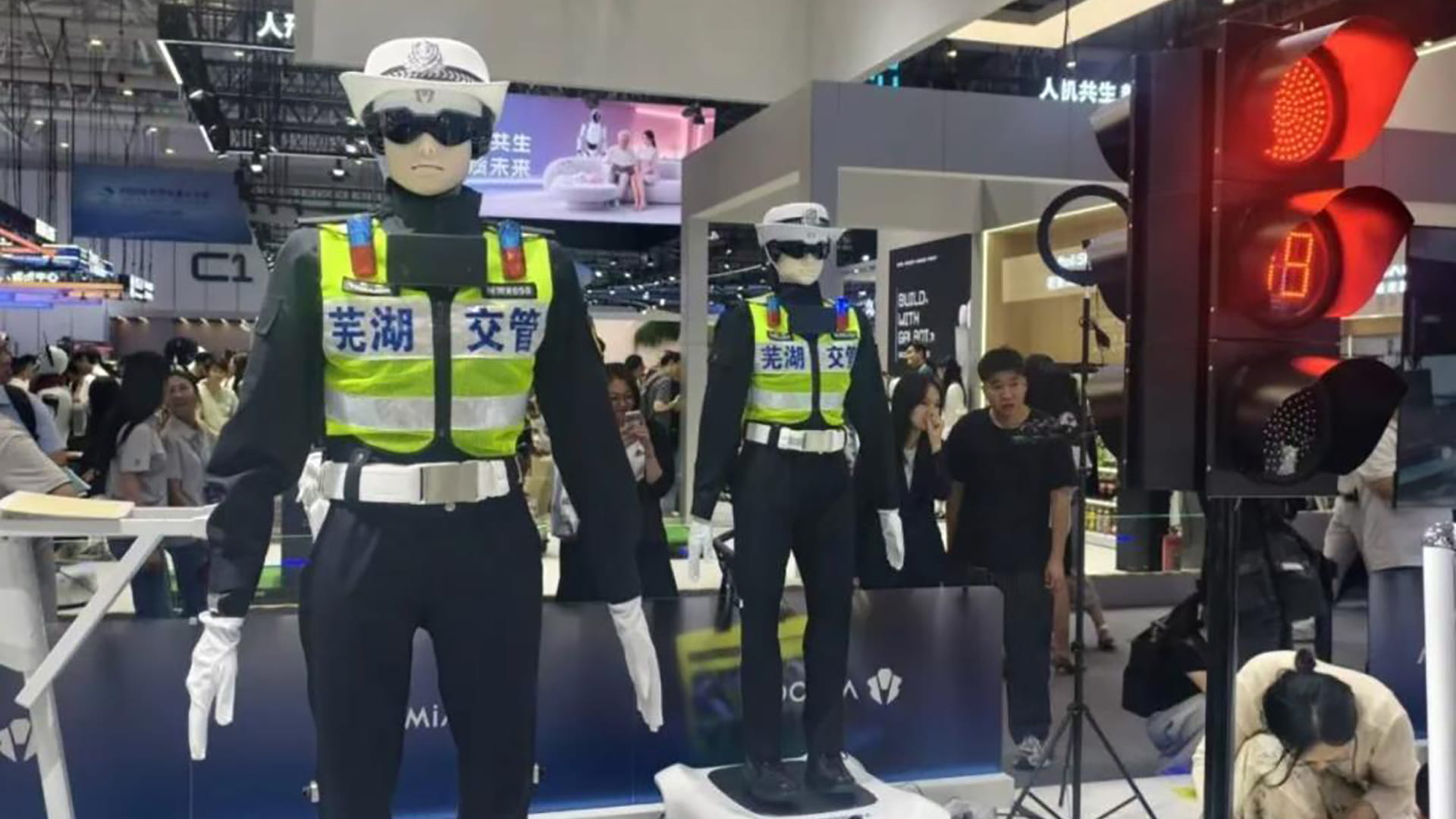 Photo shows robots wearing police-style uniforms at Aimoga Robotics’ World Robot Conference 2026 booth, where the company showcased a traffic management application.