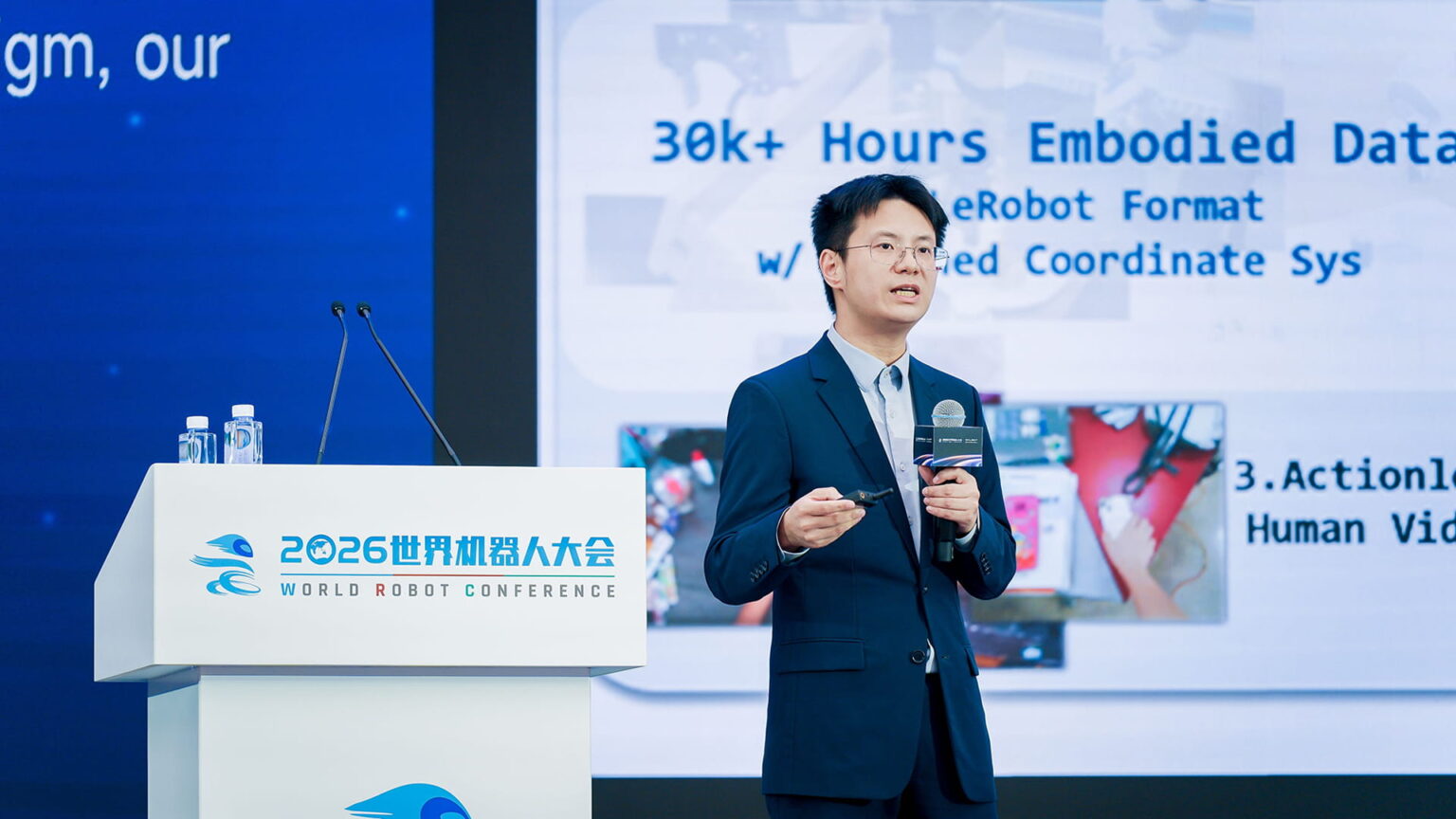 Wang He, founder and CTO of Galbot, speaking at the World Robot Conference (WRC) 2026. Photo source: Galbot.