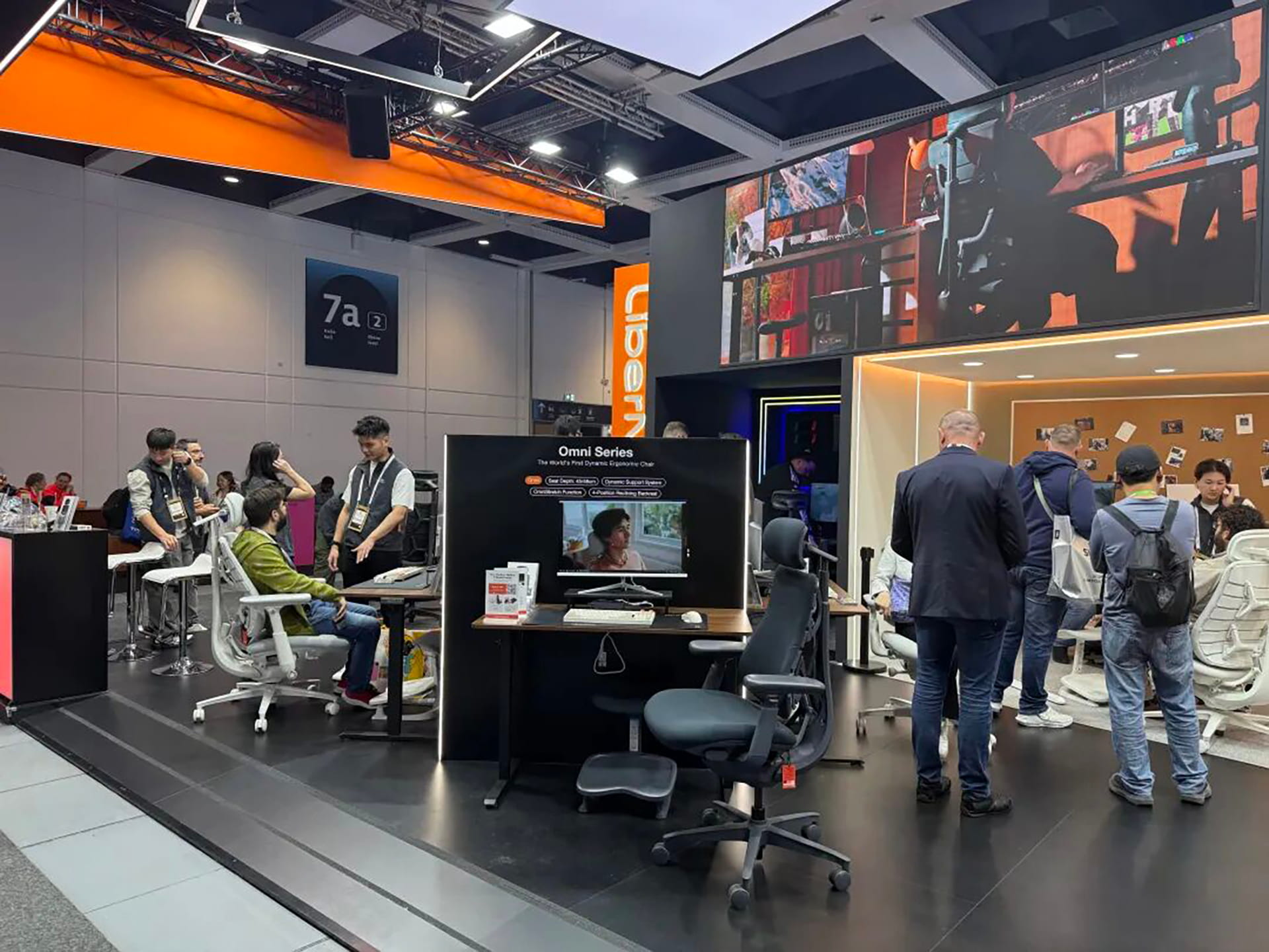Photo shows visitors trying LiberNovo’s ergonomic chairs at IFA 2026.