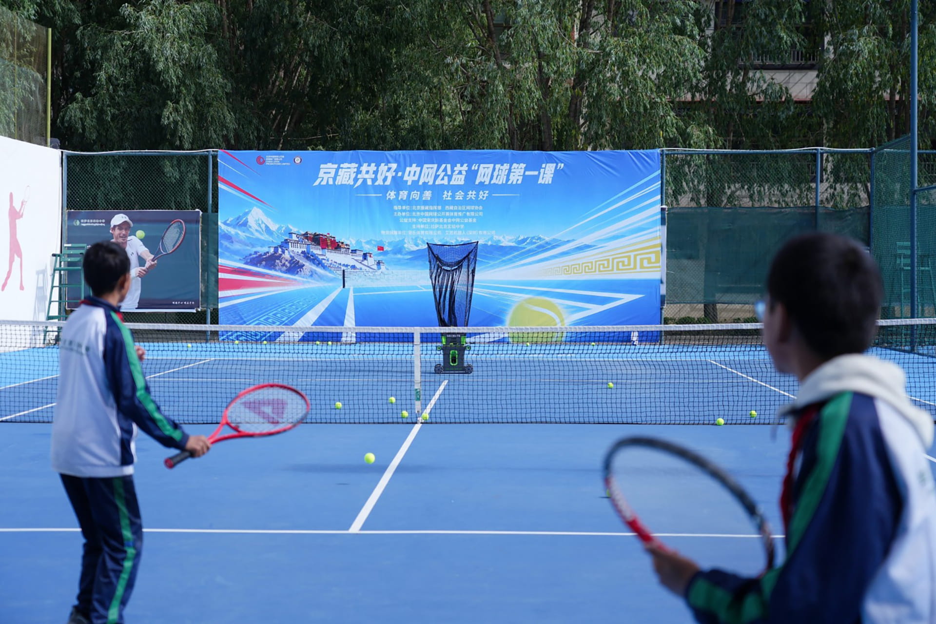 Photo shows students in a rally with the Acemate tennis robot, which is designed to deliver consistent shots, track returns, move to receive the ball, and sustain practice rallies.